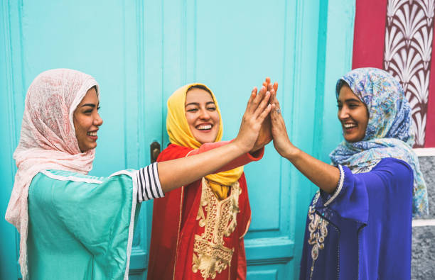 donne arabiane felici che impilano le mani all'aperto - giovani donne musulmane che si divertono e all'università - concetto di emancipazione, persone, religione e lavoro di squadra - indian costume foto e immagini stock