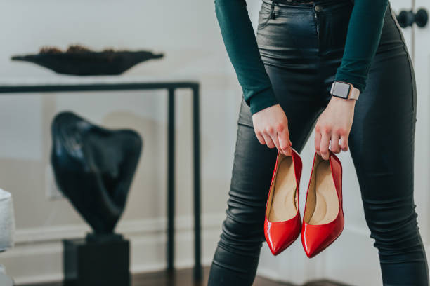 istock Woman holding red shoes 1127021152