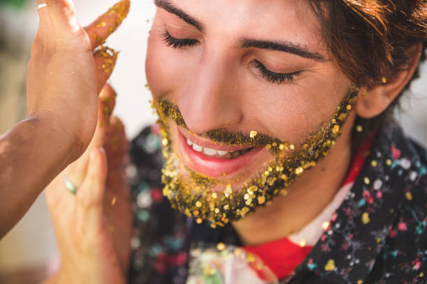 Applying golden glitter on the beard