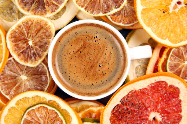 Black coffee in a white Cup surrounded by citrus dried fruits