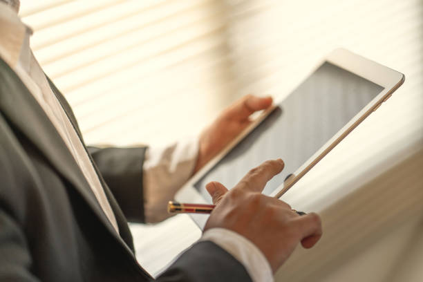 istock Businessman use computer tablet for work in communication around worldwide to success marketing plan of company 1127033034