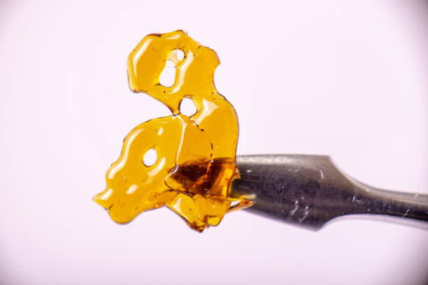 Detail of dab tool with cannabis concentrate aka shatter isolated Macro detail of dab tool with cannabis concentrate aka shatter isolated over white background, medical marijuana extraction concept dab dance photos stock pictures, royalty-free photos & images