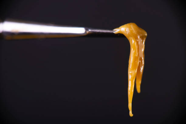 Detail of dab tool with cannabis concentrate aka rosin isolated over black Macro detail of dab tool with cannabis concentrate aka rosin isolated over black background, medical marijuana extraction concept rosin stock pictures, royalty-free photos & images