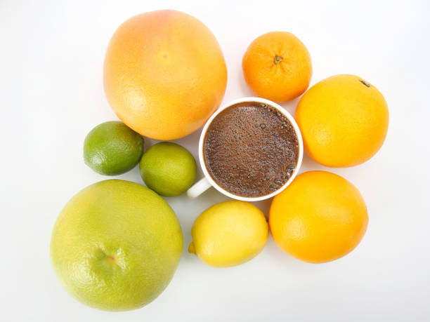 Black coffee in a white Cup surrounded by citrus fruits