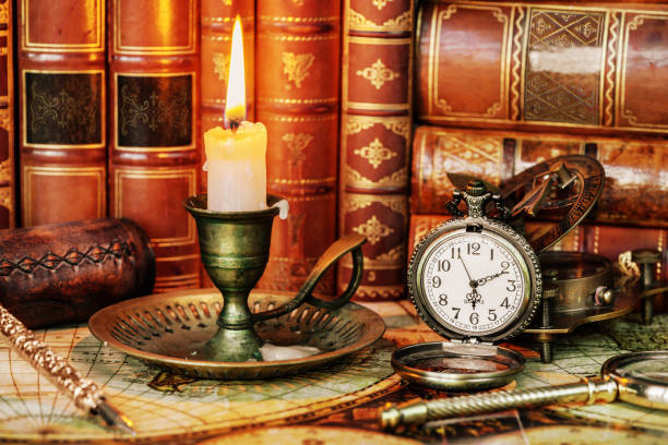 istock Pocket watch, burning candle and old books 1127041269