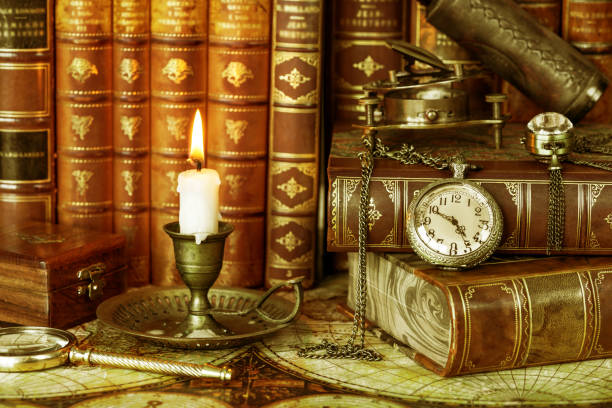 istock Pocket watch, burning candle and old books 1127047687