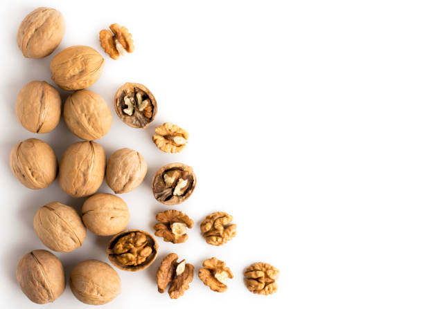 istock Walnut in shell and peeled scattered on a white. The view from the top. 1127048610
