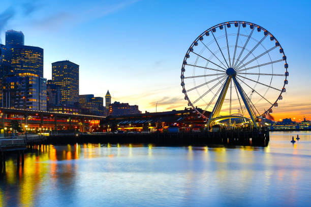 Seattle, Washington, USA - December 13, 2017: Seattle seaport sunrise with Pier 57 shops, Ferris wheel, and Seattle skyline on the background