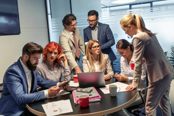 istock Group of business people working and communicating while sitting at the office desk 1127054056
