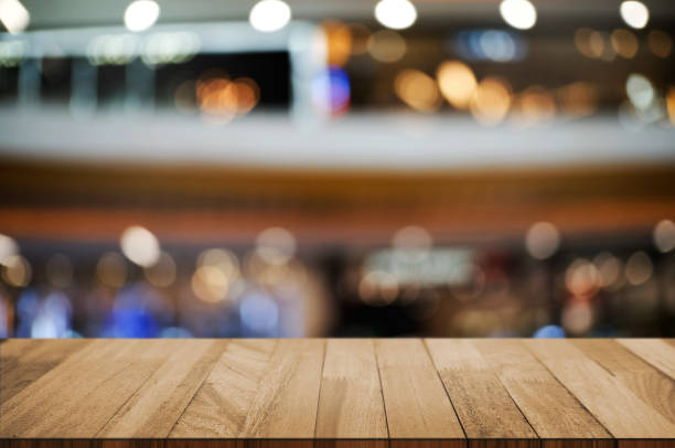 istock empty wooden tabletop over blur hypermarket background. 1127055499