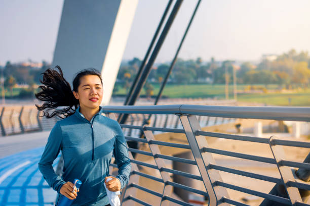 istock Woman running on the bridge on a sunny day 1127056562