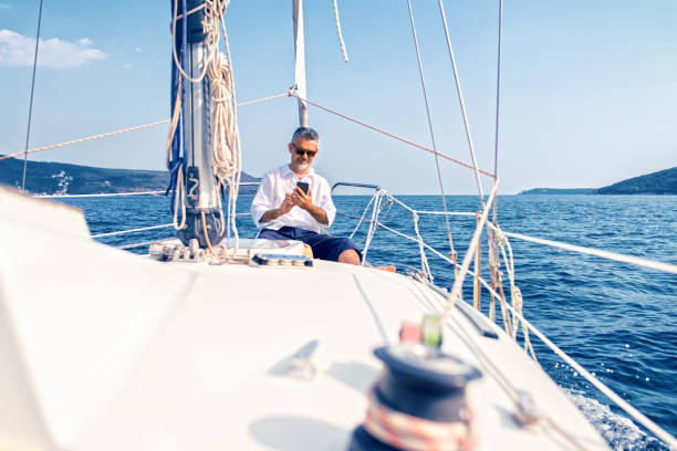 istock Man on a luxury yacht using smartphone 1127056946