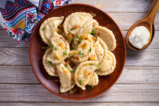 Dumplings, filled with potato. Dumplings with filling Dumplings, filled with potato. Dumplings with filling and sour cream in wooden spoon. overhead, horizontal poland stock pictures, royalty-free photos & images