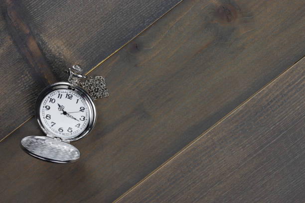 istock pocket watch on wooden table 1127059341