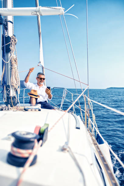 istock Man on a luxury yacht using smartphone 1127059503
