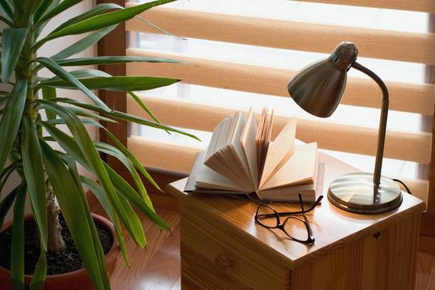 istock Book an lamp on the table, window background 1127060079