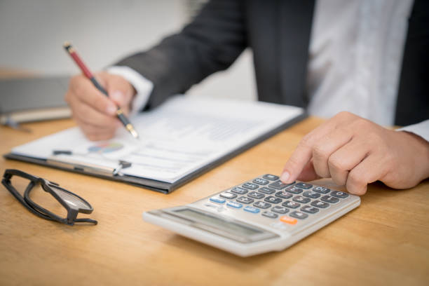 istock Start up business man or accountant checking his business graph working on laptop computer and calculator on office table. 1127060506