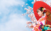 桜とアジアの女性の着物を着ています。