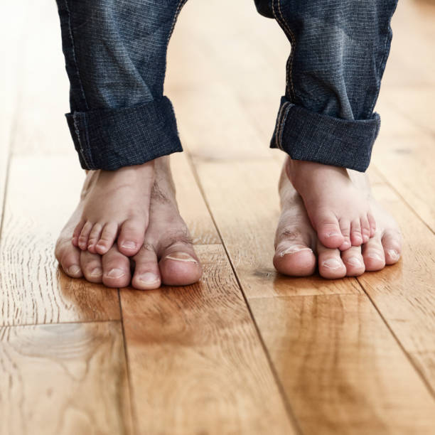 kind barfuß auf seines vaters füßen stehend - child human foot barefoot jeans stock-fotos und bilder