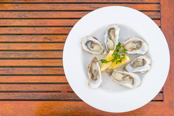 istock Selective focus point on fresh oysters shell with lemon - Top of view 1127065085