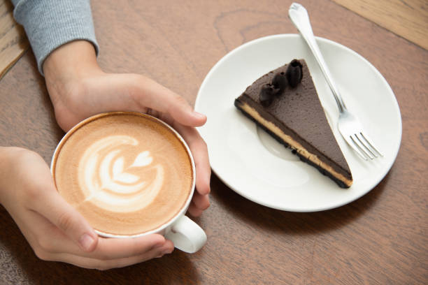 istock Woman drinking cappuccino and eating cake 1127065416