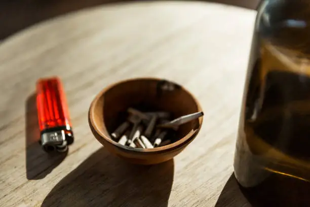 Photo of Ashtray With Smoked Joint Roaches On Table Surface