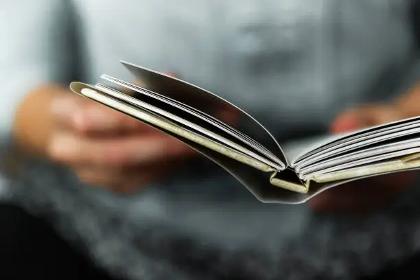 Young women reading a small book.