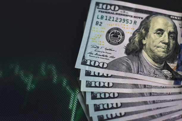 istock US dollar bills on background with dynamics of exchange rates. Trading and financial risk concept 1127066483