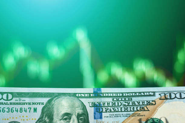 istock Dollar banknote against blurred screen stock exchange data graph. Toned photo. Business concept 1127066489