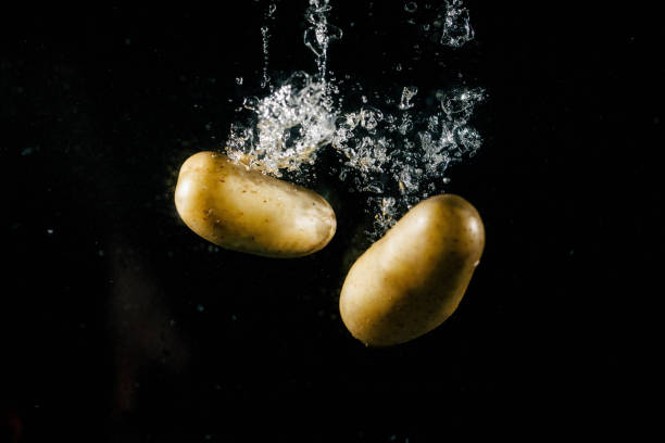 istock Two large potatos fall in water and make bubbles 1127068959