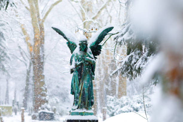 istock Antique Angel Statue on a Graveyard in deep Snow 1127069186