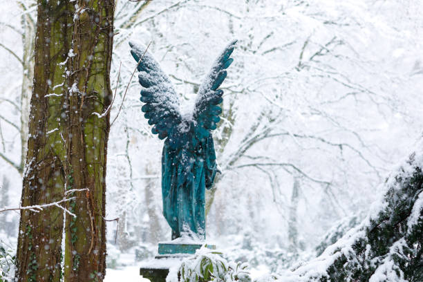 istock Antique Angel Statue on a Graveyard in deep Snow 1127069422