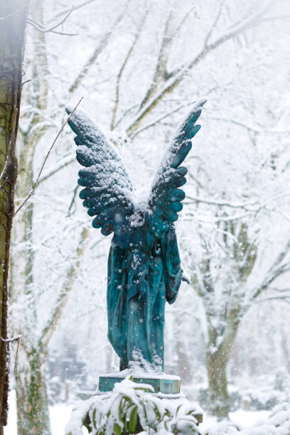 istock Antique Angel Statue on a Graveyard in deep Snow 1127070470