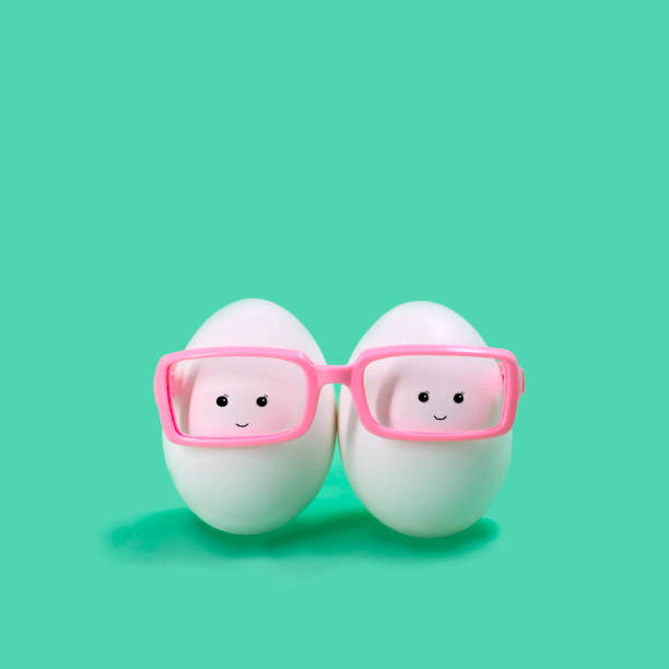 Two eggs in pink glasses like Siamese twins stock photo