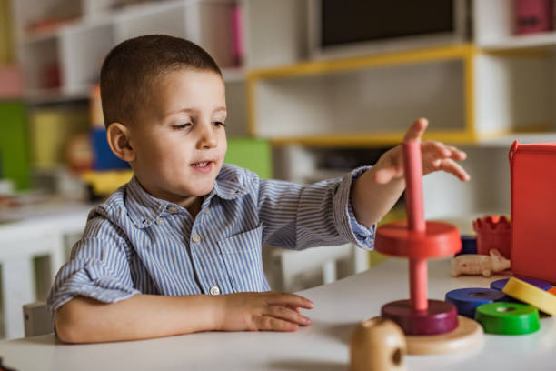istock Little boy playing with educational stacking toy at kindergarten. 1127073745