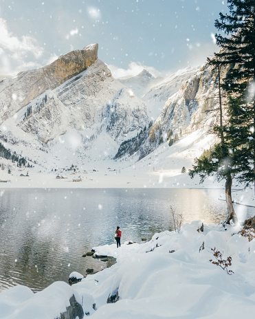 Young Caucasian woman looking at scenic view of Cauma lake in Switzerland in winter