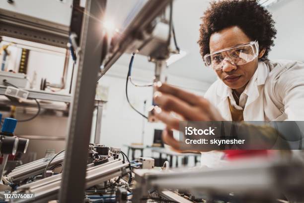 Schwarze Weibliche Ingenieur An Industrielle Maschine In Einem Labor Arbeiten Stockfoto und mehr Bilder von Ingenieur