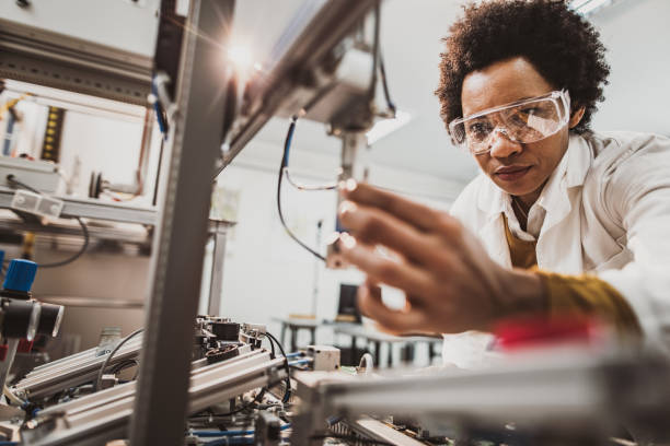 ingegnere donna nera che lavora su macchina industriale in laboratorio. - laboratory scientist african ethnicity science foto e immagini stock