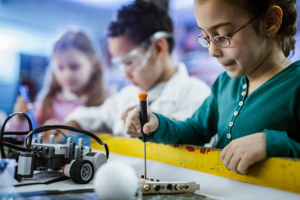 istock Small girl working on motherboard in laboratory. 1127076141
