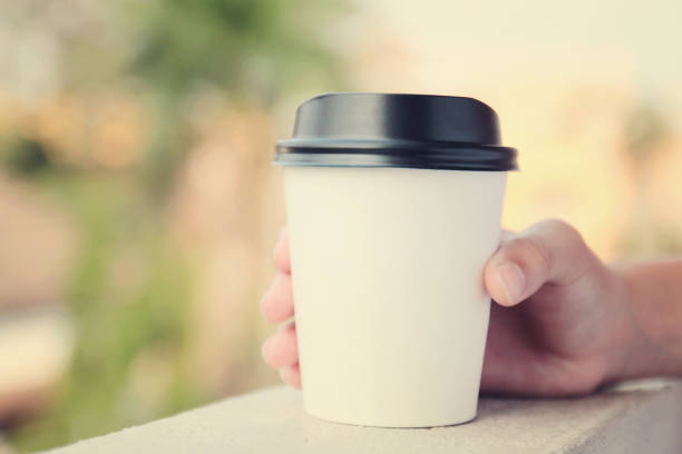 istock Hand holding take away coffee cup with retro filter effect 1127079198