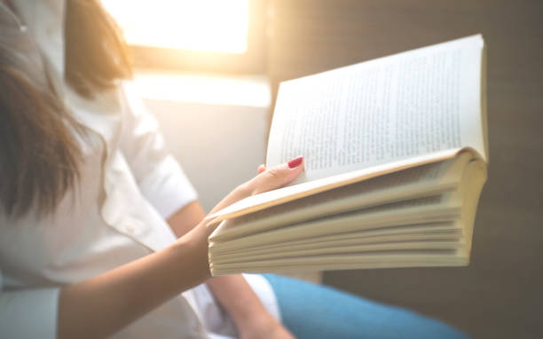 istock young woman reading a book at home. 1127079490