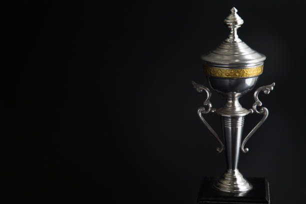 istock Close up of Silver trophy over black background. Winning awards with copy space for text and design 1127079553