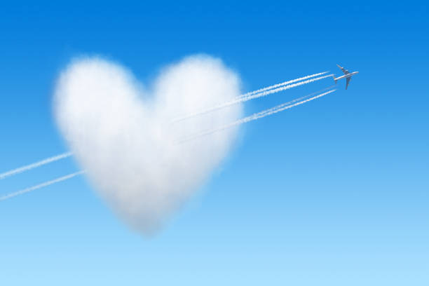 istock Airplane at the blue sky flying through a heart shaped cloud 1127081326