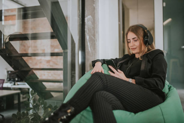 istock Happy female worker enjoying favorite music at work 1127083033