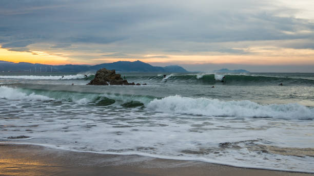 Surfers in Sopelana beach at dusk Surfers in Sopelana beach at dusk, Basque Country sopelana stock pictures, royalty-free photos & images