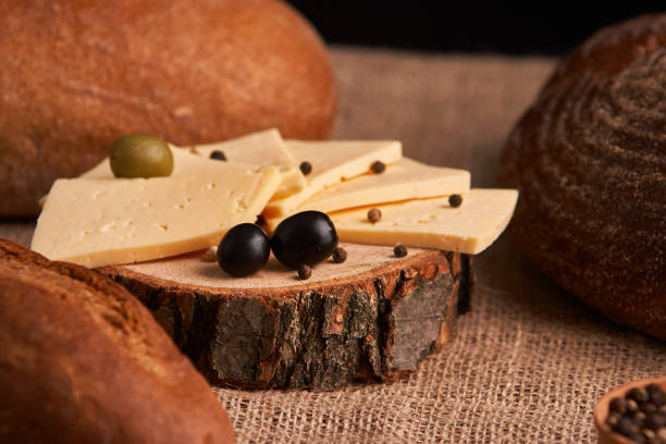 istock Slices of cheese on wooden desk between different breads. place for text 1127087697