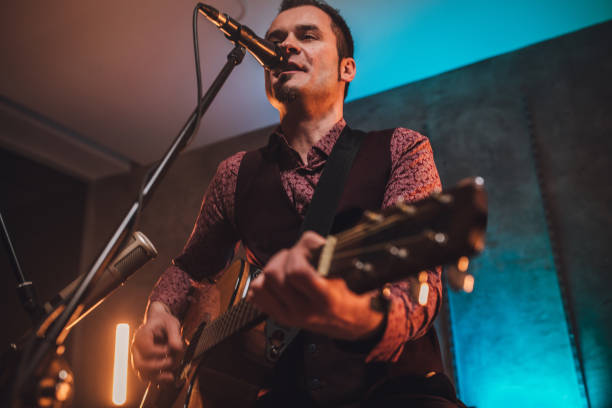 istock Rock musician singing and playing acoustic guitar 1127087880