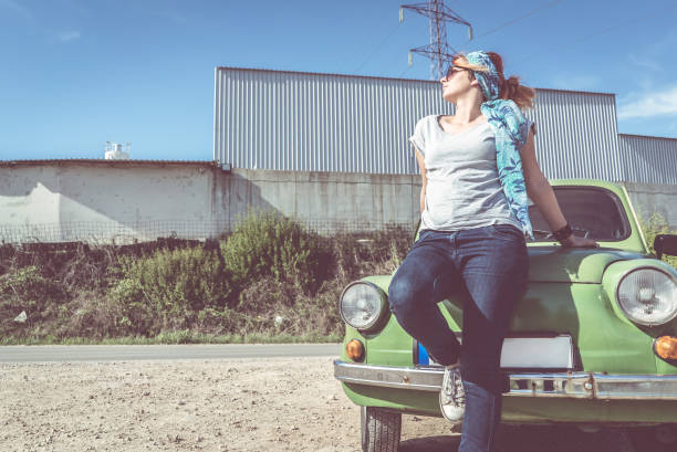 istock Redhead girl posing on car hood 1127088487