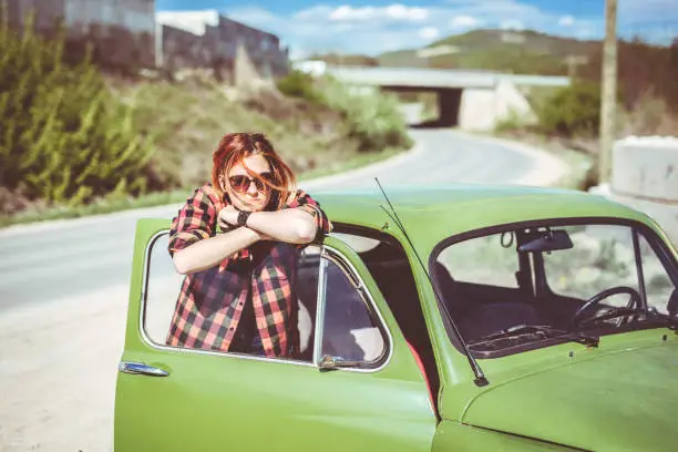 Photo of Redhead girl leaning on car door