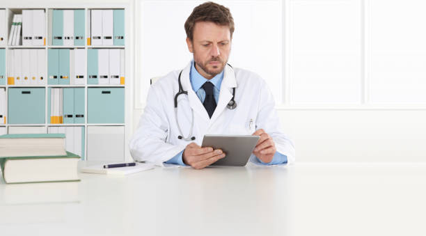 Doctor writing prescription at desk in medical office with digital tablet, copy space and web banner template Doctor writing prescription at desk in medical office with digital tablet, copy space and web banner template anamnesis stock pictures, royalty-free photos & images